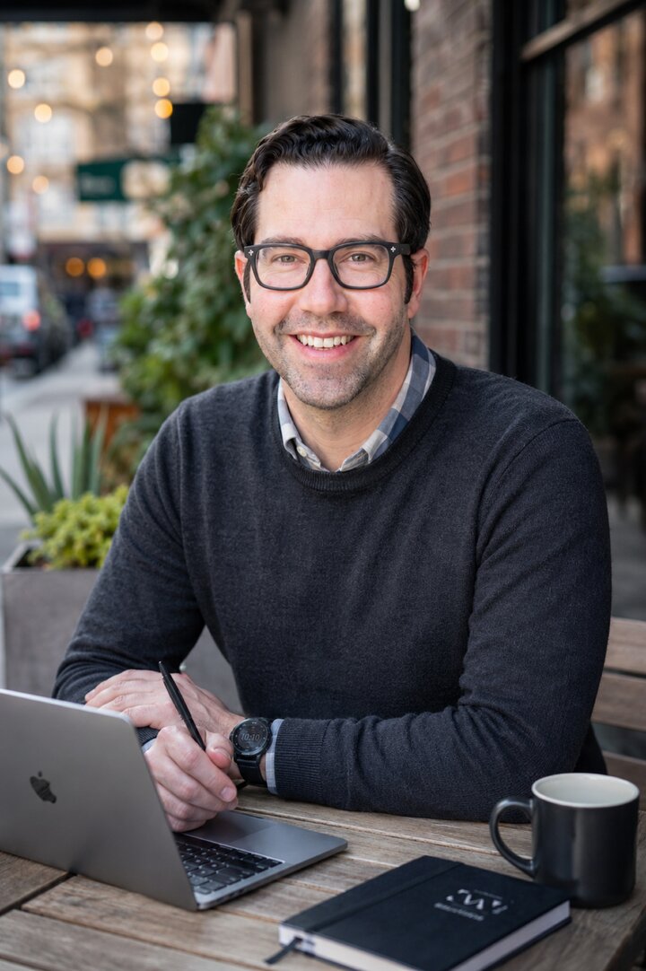 Scott Harris working on a laptop at an outdoor coffee shop